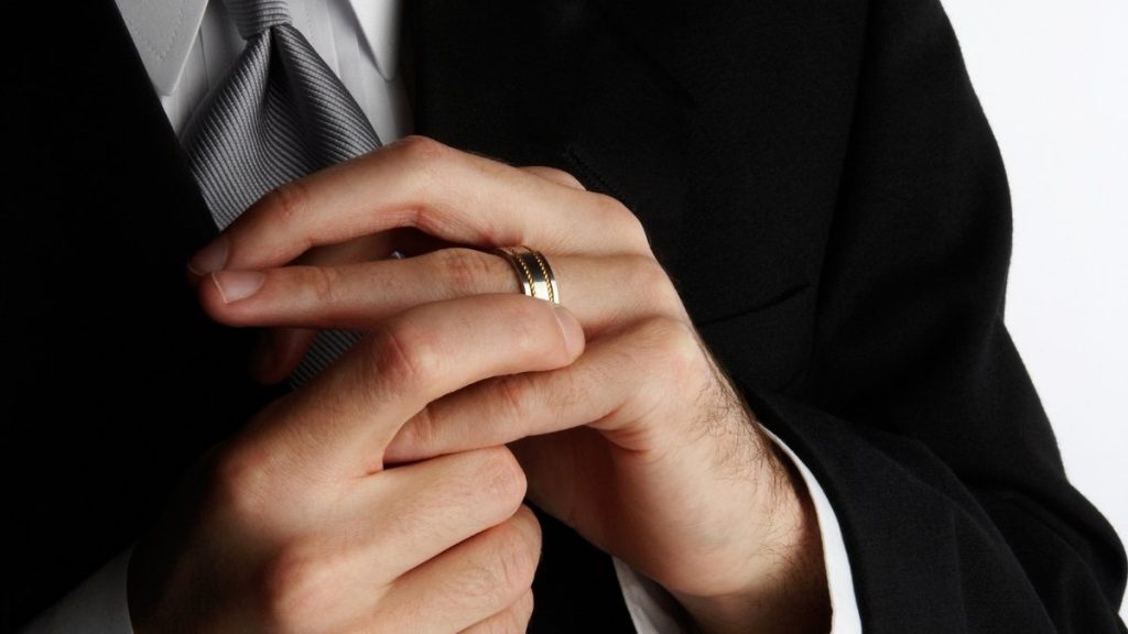 man die zijn trouwring aanraakt