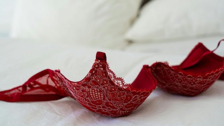 rode lingerie uitgestald op een bed
