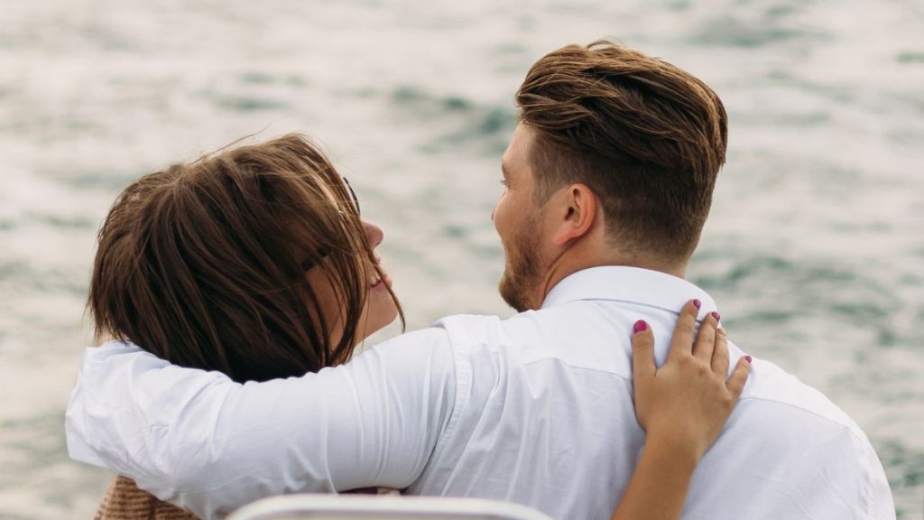 vrouw en man op een boot die elkaar aankijken en lachen