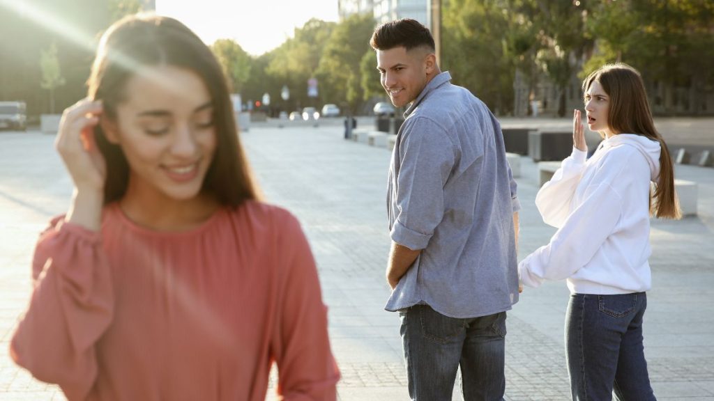 man en vrouw lopen samen, man kijkt naar een andere vrouw