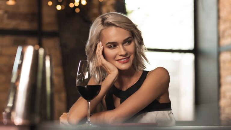 vrouw die dromerig over een bartafel staart