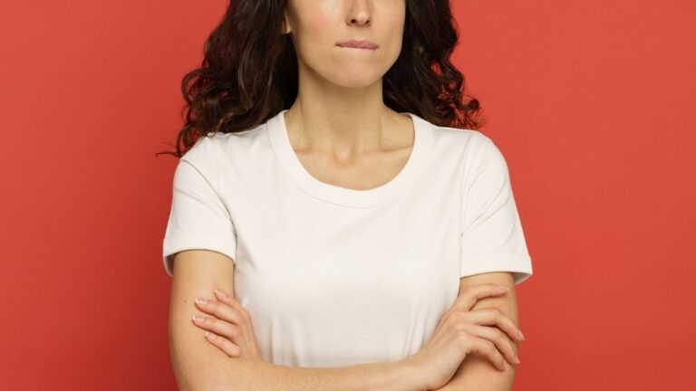 Vrouw met gekruiste armen en een bezorgde uitdrukking op haar gezicht